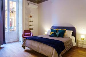 Schlafzimmer mit einem Kingsize-Bett und einem roten Stuhl in der Unterkunft Le Volte And Suite in Catania