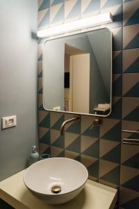 ein Bad mit einem Waschbecken und einem Spiegel in der Unterkunft Le Volte And Suite in Catania