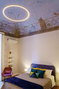 a bedroom with a ceiling with a painting at Le Volte and Suite in Catania