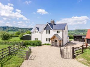 a white house with a fence and a field at 4 Bed in Llanidloes 51651 in Llandinam