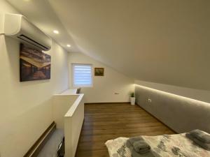 Habitación blanca con cama y ventana en Apartman Marsalforn, en Veternik