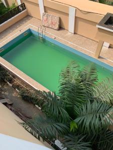 een zwembad met een palmplant erin bij Modern 2BDR APT - Wi-Fi, Kitchenette, Pool & 24hrs Security, Netflix in Ikeja
