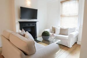 a living room with two white couches and a fireplace at Charming 2-Bed in Windsor: Walk to all the sites! in Windsor