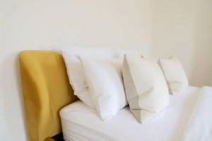 a white couch with four white pillows on it at Charming 2-Bed in Windsor: Walk to all the sites! in Windsor