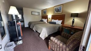 una camera d'albergo con due letti e un divano di Economy Inn a Garnett