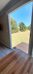 una puerta abierta a un patio con vistas a un campo en Casas Containers - Barrio Los Teros con pileta compartida - Santa Clara del Mar en Santa Clara del Mar