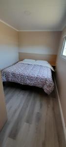 1 dormitorio con 1 cama con 2 almohadas en Casas Containers - Barrio Los Teros con pileta compartida - Santa Clara del Mar en Santa Clara del Mar