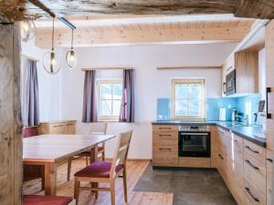 eine Küche mit einem Holztisch und einem Esszimmer in der Unterkunft Haus 1683 - Wolfbauer in Johnsbach