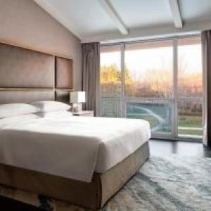 um quarto com uma cama grande e uma janela grande em Lincolnshire Marriott Resort em Lincolnshire