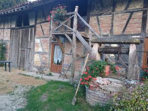 une maison avec une échelle et des fleurs devant elle dans l'établissement A La Poularde B&B, à Curciat-Dongalon