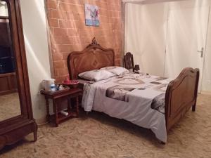- une chambre avec un lit et un mur en briques dans l'établissement A La Poularde B&B, à Curciat-Dongalon