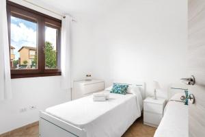 Villa Hermosa في Telti: غرفة نوم بيضاء بها سرير ونافذة