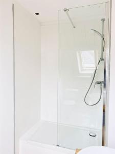 a white bathroom with a shower and a sink at Le Cinquante in Groix