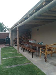 a group of benches sitting under a pavilion at Hermosa casita con quincho y amplia pileta TODAS LAS COMODIDADES Paz total in Ullún