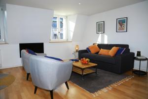 uma sala de estar com um sofá, cadeiras e uma mesa em *Hypercentre*Spacieux*Calme - Le Vauban - Cocoonhome em Besançon