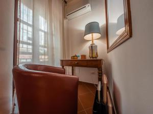 パレルモにあるCasa Ruggieroの椅子、デスク、ランプが備わる客室です。