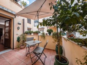 un patio con mesa, sillas y macetas en Casa Ruggiero, en Palermo