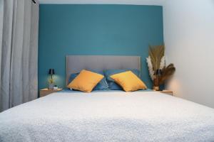 um quarto azul com uma cama com 2 almofadas amarelas em *Hypercentre*Spacieux*Calme - Le Vauban - Cocoonhome em Besançon