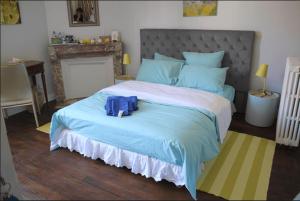 een slaapkamer met een groot bed met een blauwe tas erop bij Manoir de Bréançon 