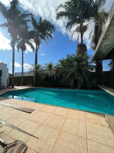 a swimming pool with palm trees in the background at CORTESE HOTEL in Tatuí