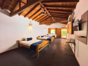 a row of beds in a room with wooden ceilings at Encomendero Hotel -Centro Histórico- in Santa Fe de Antioquia +82 photos