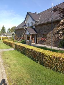 una casa con un seto delante de ella en Ferienwohnung Biebes en Höfen