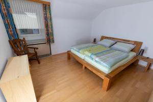 1 dormitorio con cama, mesa y ventana en Ferienwohnung Biebes en Höfen