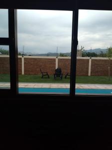 a window with a view of a bench in a yard at Hermosa casita con quincho y amplia pileta TODAS LAS COMODIDADES Paz total in Ullún