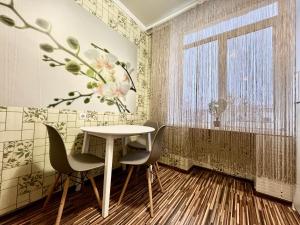 a dining room with a table and chairs and a window at Apartament central în Chișinău! in Chişinău