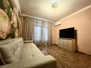 a living room with a couch and a flat screen tv at Apartament central în Chișinău! in Chişinău