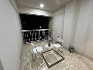 a table and chairs in a room with a balcony at Udaipur Apartments In The City Of Lakes By Especial Rentals in Udaipur