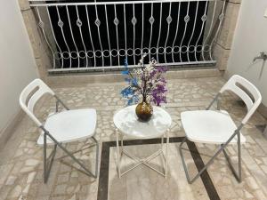 a table with two chairs and a vase with flowers on it at Udaipur Apartments In The City Of Lakes By Especial Rentals in Udaipur