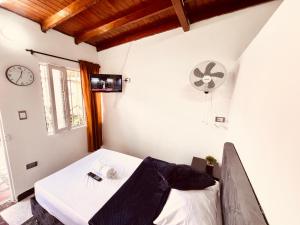 um quarto com uma cama e um relógio na parede em Hospedaje La Nave em Bello
