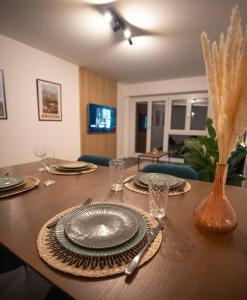 - une table à manger avec des assiettes et des ustensiles dans l'établissement Appartement spacieux au centre de la Gruyère, à Broc