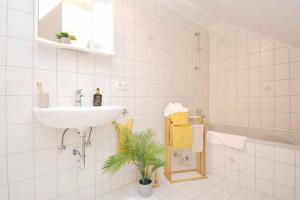 a white bathroom with a sink and a bath tub at KU03-RI Apartment in Kulmbach DG in Kulmbach