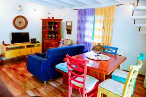 a living room with a table and a blue couch at Casa a 220m da Praia de Boicucanga-Sao Sebastiao in São Sebastião