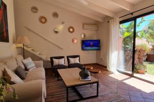 ein Wohnzimmer mit einem Sofa und einem Tisch in der Unterkunft Bonita casa rural con jardín y terraza privado in Jimena de la Frontera