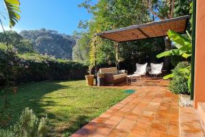 einen Hinterhof mit einer Couch und einer Pergola in der Unterkunft Bonita casa rural con jardín y terraza privado in Jimena de la Frontera