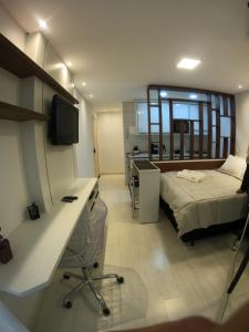 a bedroom with a bed and a desk with a desk at Studio novíssimo e aconchegante no Juvevê. in Curitiba
