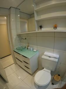 a bathroom with a white toilet and a sink at Studio novíssimo e aconchegante no Juvevê. in Curitiba