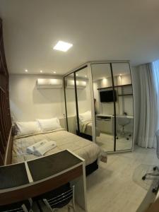 Habitación de hotel con cama y espejo en Studio novíssimo e aconchegante no Juvevê., en Curitiba