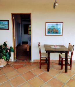 uma sala de jantar com uma mesa e cadeiras num quarto em Finca Emilio em Fredonia