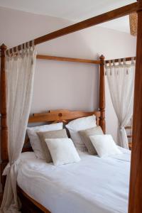 1 dormitorio con 1 cama con almohadas blancas en Maison d'hôte de l'Aber - Sable, en Crozon