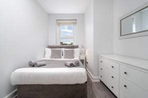 um quarto branco com uma cama e uma janela em Spacious 2bed Brick Lane flat - 2nd Floor em Londres