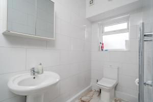 Baño blanco con lavabo y aseo en Spacious 2bed Brick Lane flat - 2nd Floor, en Londres