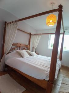 1 dormitorio con 1 cama grande con marco de madera en Maison d'hôte de l'Aber - Sable en Crozon