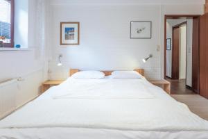 Am Schlosspark في هوسوم: سرير أبيض كبير في غرفة نوم بيضاء