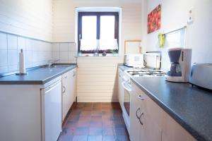 Am Schlosspark في هوسوم: مطبخ مع حوض وموقد الفرن العلوي +صورتان