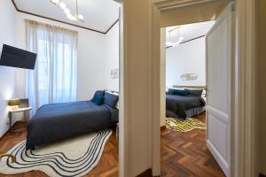 ein Schlafzimmer mit 2 Betten und eine Tür mit einem Spiegel in der Unterkunft IREX Vatican private apartment in Rom