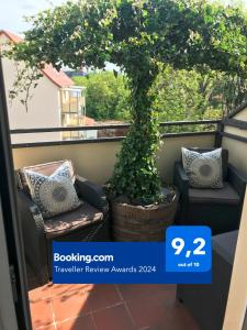 a balcony with a bonsai tree and two chairs at Stadtdschungel FeWo mit Balkon in Cottbus